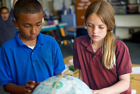 Students studying a globe