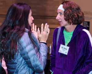 Two women are engaged in conversation, one wearing a name tag labeled "Dr. Katy.